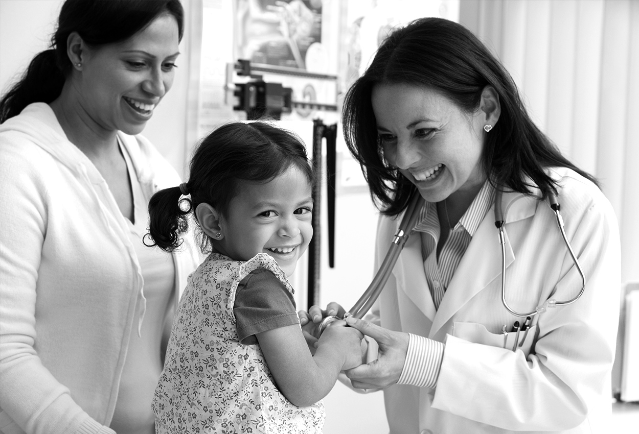 Female doctor with a pediatric patient and her mother