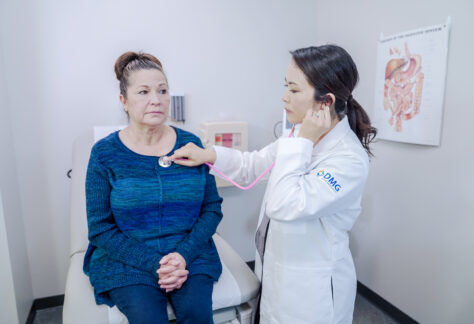 A female doctor using a stethoscope to check a hispanic women