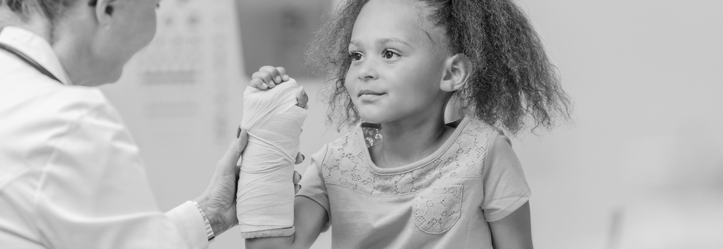 Orthopedic doctor checks on young girl's broken arm