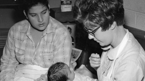 1962 maternity nurse holding newborn